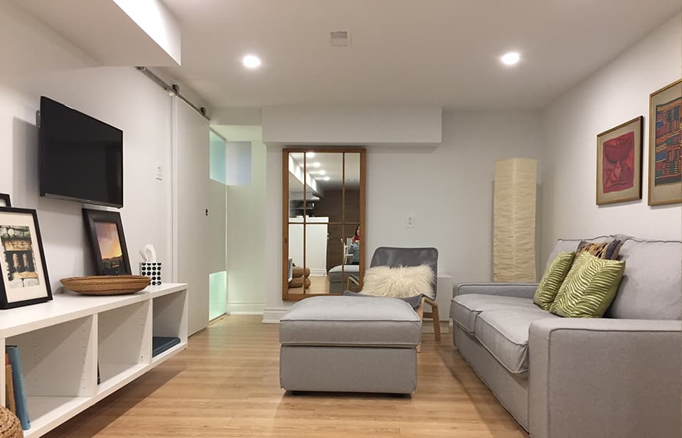 Basement apartment living area with light wood accents and natural lighting